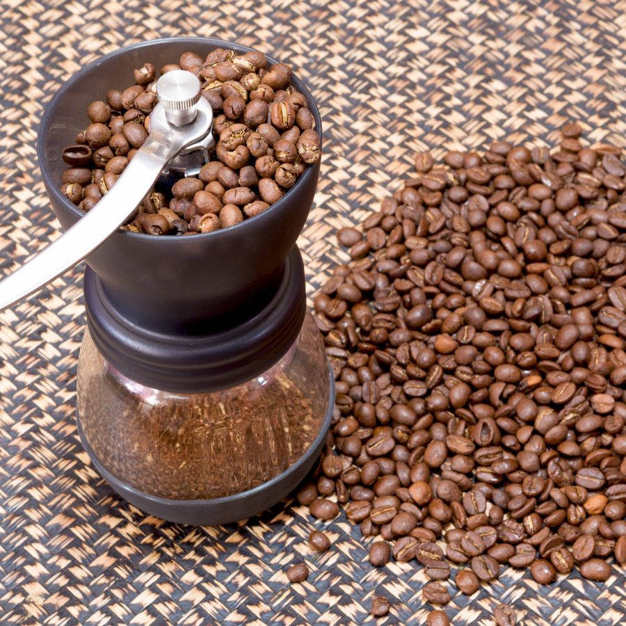 coffee grinder with coffee bean on rattan tray