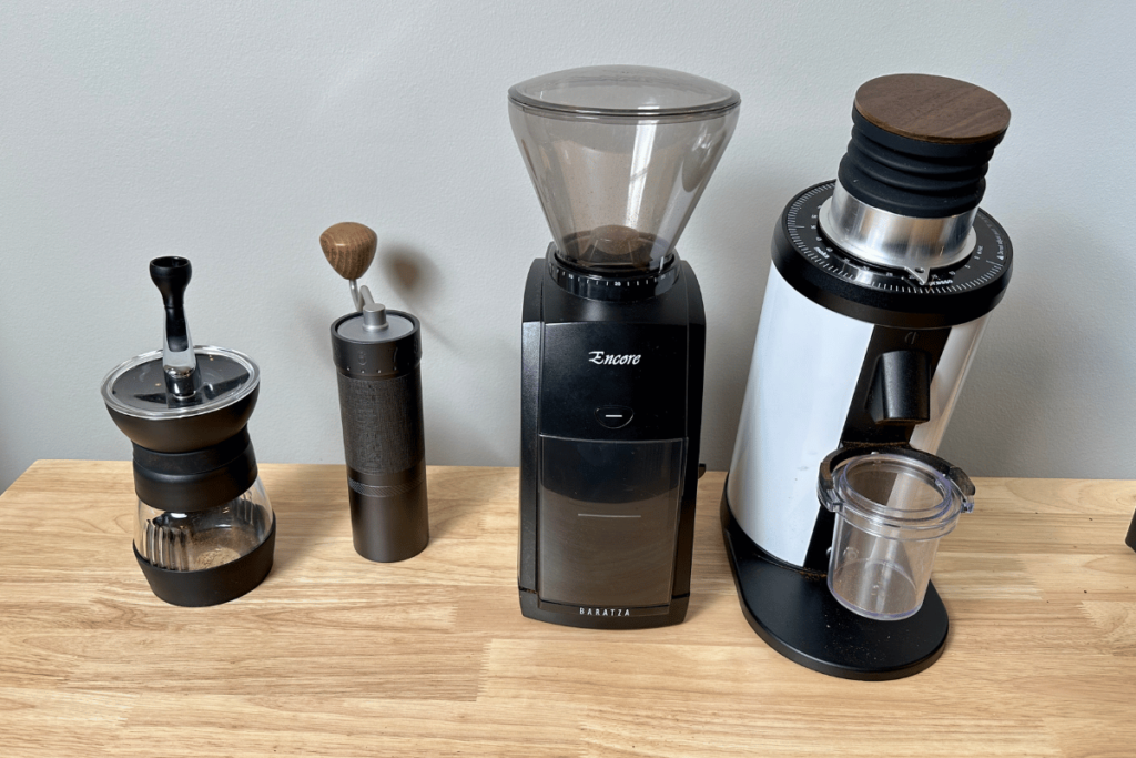 two manual coffee grinder next to two electric coffee grinders
