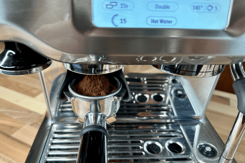 coffee grounds dosing into a portafilter on a Breville