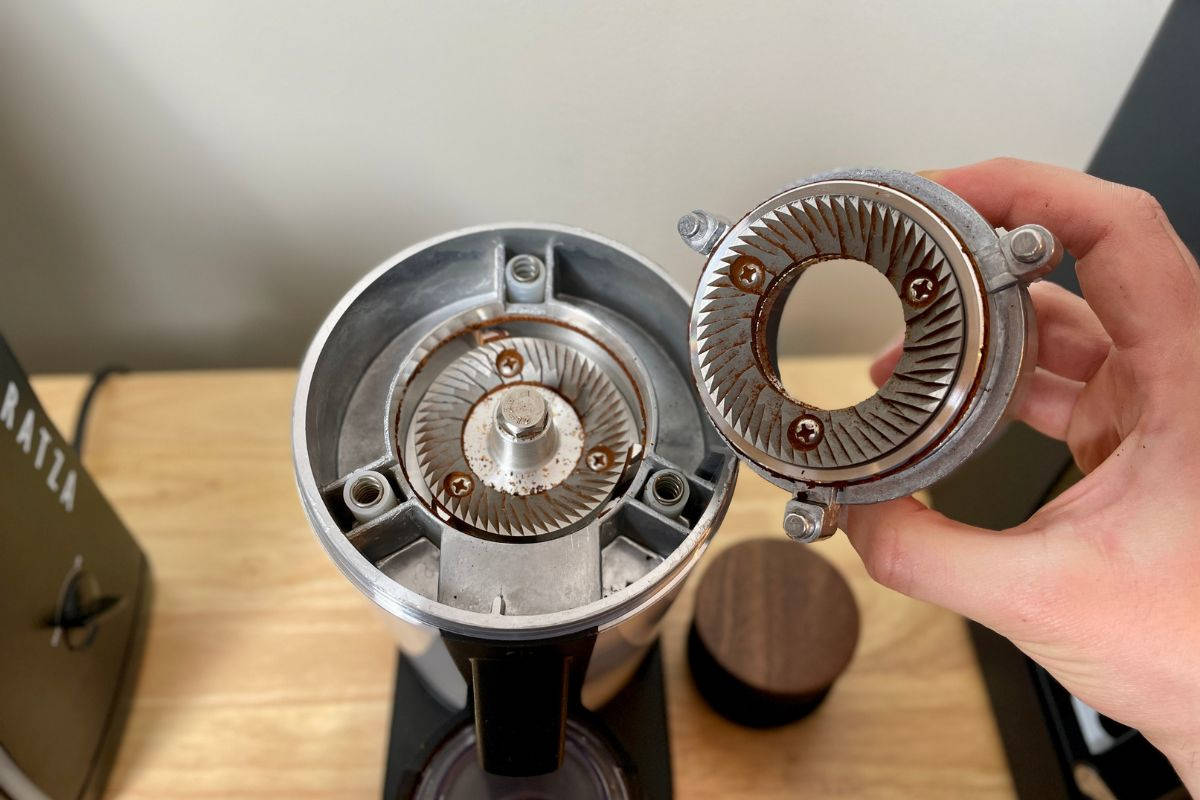 flat burr grinder with lots of old ground coffee before cleaning, to show the concept of grind retention for burr grinders