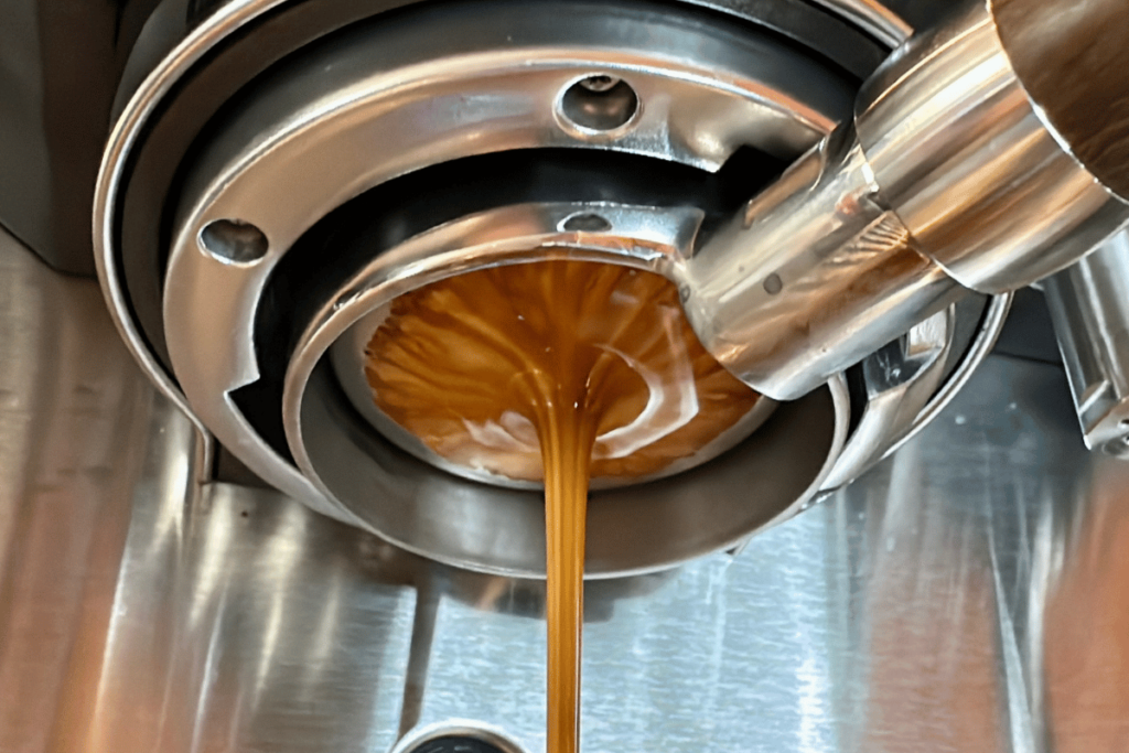 a column of espresso flowing from a bottomless portafilter