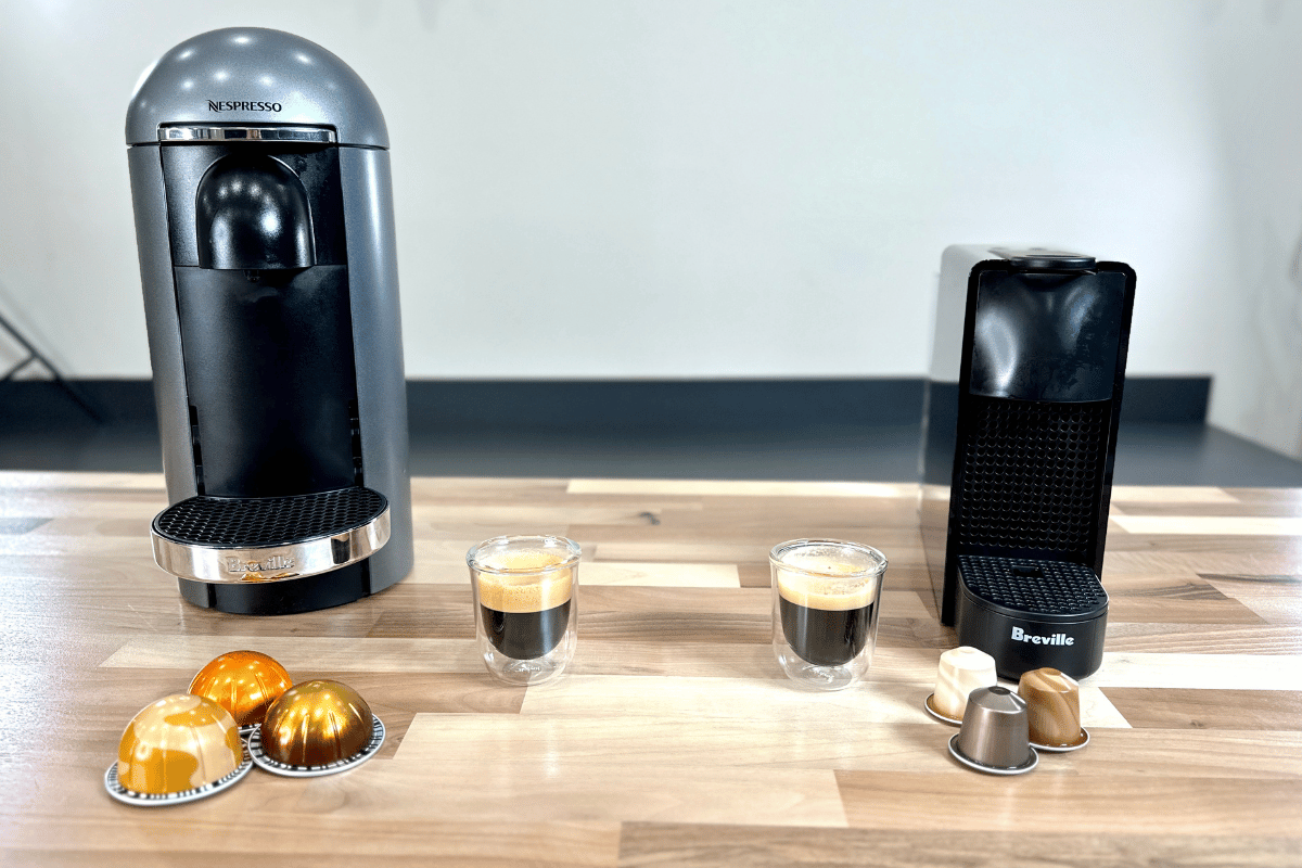 a nespresso vertuo vs a nespresso original machine with pods and coffee on table.