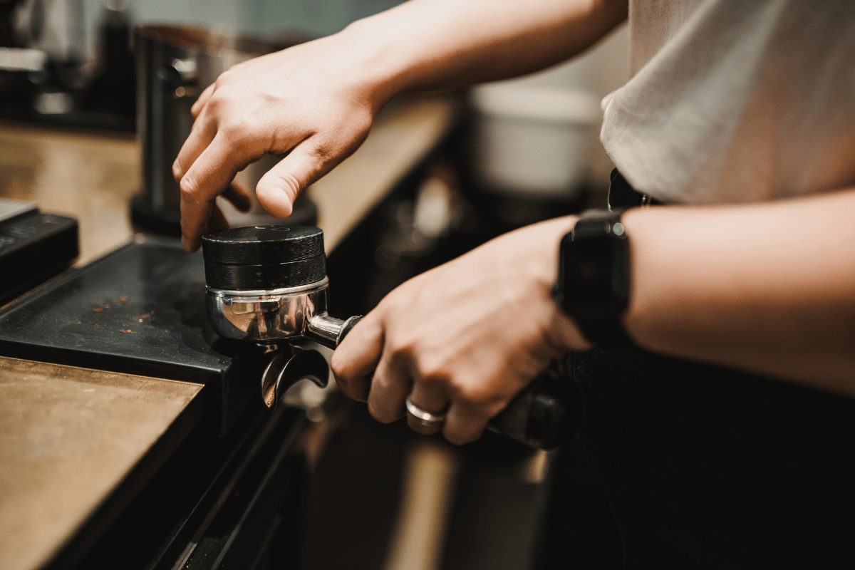 barista using a distributor when preparing espresso