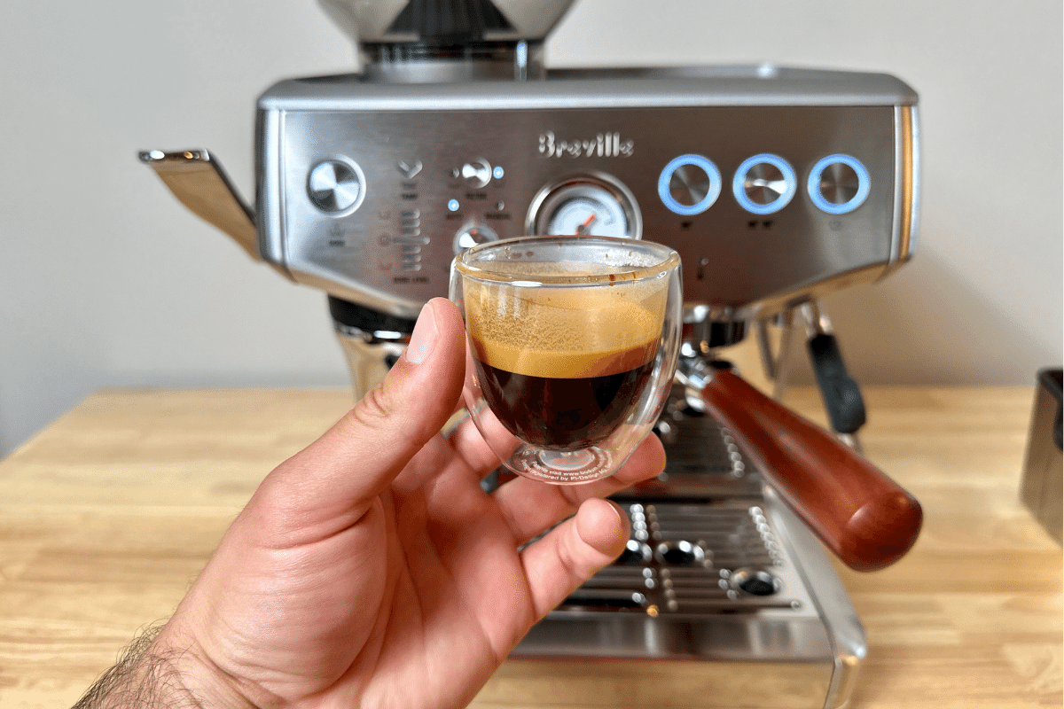 espresso shot in front of a Breville Barista Express Impress